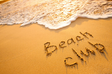 The word Beach club written in the sand on beach