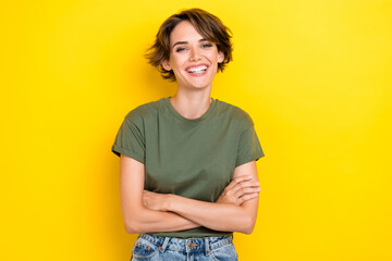 Photo of adorable lovely pretty girl with bob hairstyle wear khaki t-shirt arms crossed laughing isolated on yellow color background