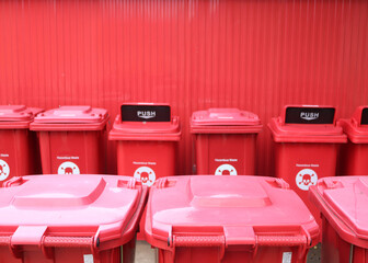 Stack of biological biohazard infected red bins. Sign showing the biological hazard symbol. According the world health organisation.
