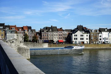Foto op Plexiglas Binnenschifffahrt an der Sint Servaasbrug vor blauem Himmel im Sommer bei Sonnenschein mit Blick auf das Ufer der Maas in Maastricht in der Provinz Limburg der Niederlande © Martin Debus