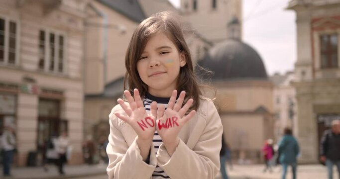 Ukrainian kid with sign no war on hand palms