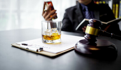 Glasses of whiskey in businessman's hands on wooden table background