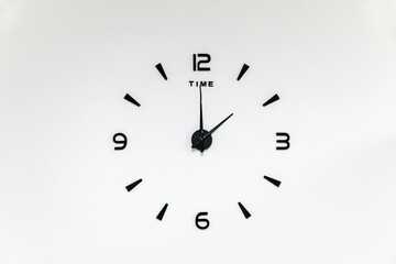 minimalistic black numbers and arrows of a wall clock on a white background - obrazy, fototapety, plakaty