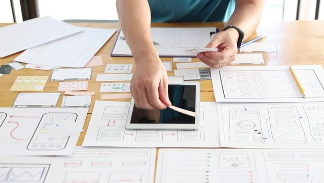 UX UI Concept, Graphic designers work together with UX UI designer planning application template layout framework for mobile phone computer mobile