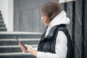 Business young woman with a tablet on the background of the building.