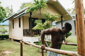 African-american man doing push ups on sports ground outdoors