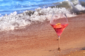 Wine glass with a cocktail by the sea.