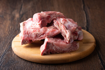 Soft focus on raw bone-in pork meat on a cutting board.