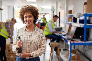 Portrait Of Female Manager In Logistics Distribution Warehouse Using Digital Tablet