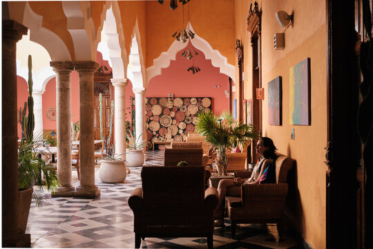 Girl waiting in a chair in a hall of an hacienda 