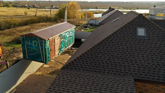 Delivery And Installation Of A Turnkey Bath. The Crane Sets Up The House. Crane And Private Construction. A Truck Crane Lifts A Building Against The Backdrop Of A Private House. 