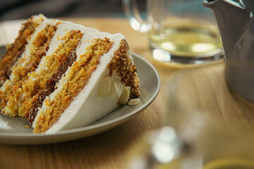 A piece of cake on a plate and a cup close-up on a table in a cafe.