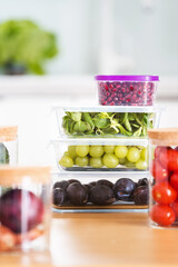 food glass containers with fresh fruits and vegetables at kitchen