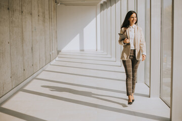 Young businesswoman walking on modern office hallway