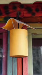 A yellow retro interior light hanging from a wooden ceiling accent, Retro lantern