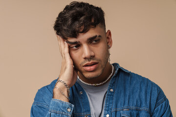 Young handsome stylish tired man holding his head , touching cheek