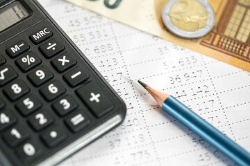 Calculator, money and pencil close-up on a blurred background.