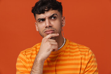 Young handsome stylish thoughtful man touching his chin