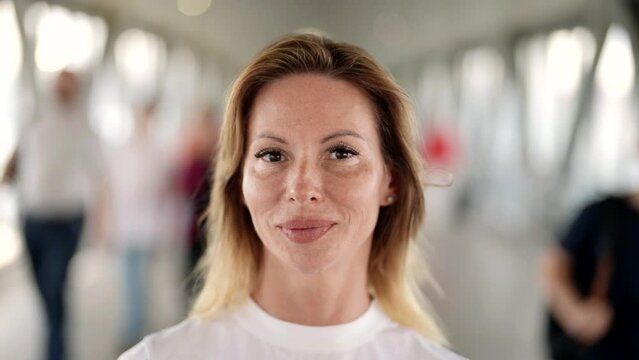 portrait of pretty adult woman in pedestrian tunnel in city, smiling female face, closeup