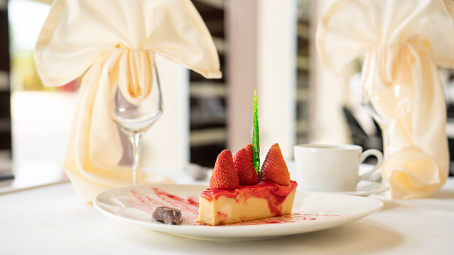 Beautifully served dessert food on a plate. Cheesecake with strawberry