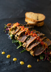 beef with vegetables, sauce, and bread. mexican dish arrachera. black background