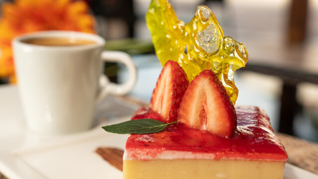Beautiful served dessert. Strawberry cheesecake. Gerbera flower, coffee and restaurant background