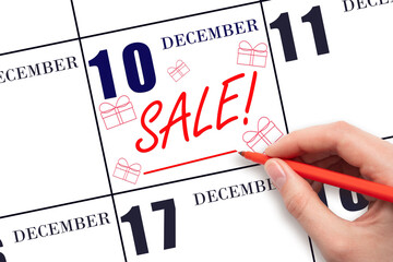 Hand writing text SALE and drawing gift boxes on calendar date December 10. Shopping Reminder