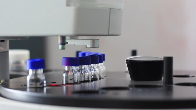 a special device with a needle draws a substance from a flask