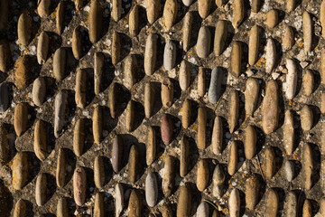Textured background pattern of irregular stones in rows or columns decorate a roadway on a street in Luesia, Aragon, Spain