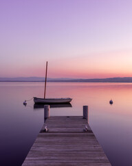 Fototapeta na wymiar Barque devant son ponton sur le lac Léman, tôt le matin
