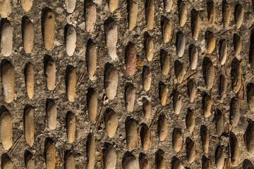 Textured background pattern of irregular stones in rows or columns decorate a roadway on a street in Luesia, Aragon, Spain