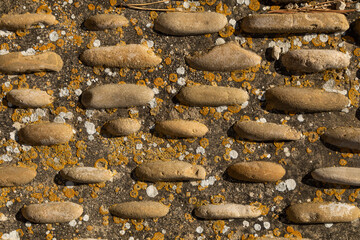 Textured background pattern of irregular stones in rows or columns decorate a roadway on a street in Luesia, Aragon, Spain
