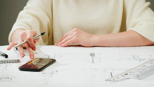 Architect designer counting on a calculator, drawing plan blueprint close-up. Professional engineer working, interior creator making architectural house project, drafting building.