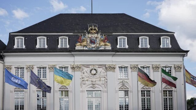 Flags wave in front of old town hall in Bonn, Germany. It was built in rococo style 1737 - 1738 by the architect of the imperial court Michael Leveilly.