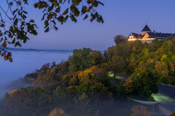 Fototapeta na wymiar View to german palais called Waldeck in the morning with fog over the lake Edersee