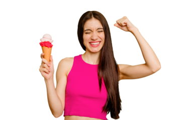 Young caucasian woman eating an ice cream isolated raising fist after a victory, winner concept.