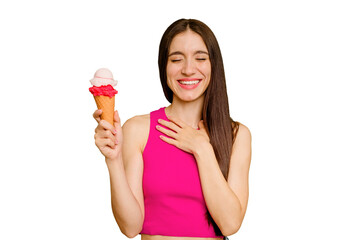 Young caucasian woman eating an ice cream isolated laughs out loudly keeping hand on chest.