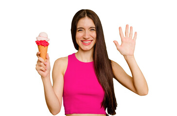 Young caucasian woman eating an ice cream isolated smiling cheerful showing number five with fingers.