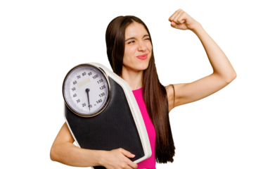 Young caucasian woman holding a scale isolated raising fist after a victory, winner concept.