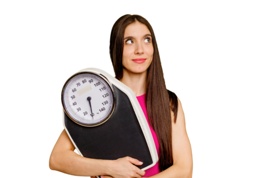 Young caucasian woman holding a scale isolated dreaming of achieving goals and purposes