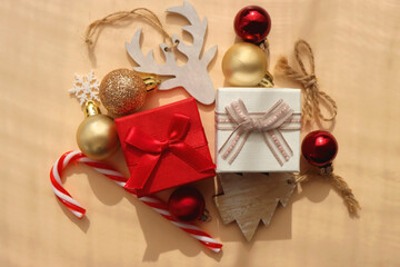 Small presents and various Christmas ornaments on neutral background. Top view.