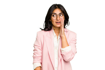 Young Indian business woman wearing a pink suit isolated is saying a secret hot braking news and...