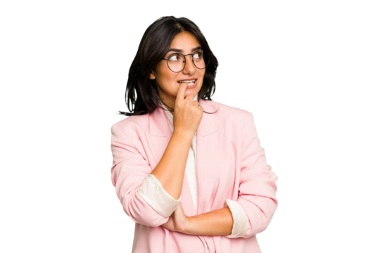 Young Indian business woman wearing a pink suit isolated relaxed thinking about something looking at a copy space.