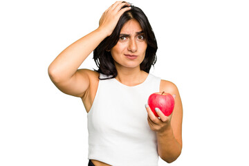 Young Indian woman holding an apple, healthy lifestyle, isolated being shocked, she has remembered important meeting.