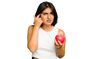 Young Indian woman holding an apple, healthy lifestyle, isolated showing a disappointment gesture with forefinger.