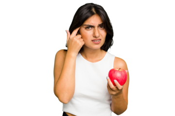 Young Indian woman holding an apple, healthy lifestyle, isolated showing a disappointment gesture with forefinger.