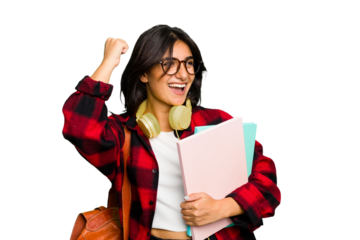 Young student Indian woman wearing headphones isolated raising fist after a victory, winner concept.