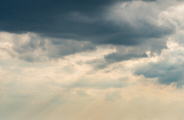 Dramatic Sky Background with sunny beams. Panoramic view of Stormy Clouds in Dark sky