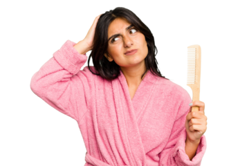 Young woman in a bathrobe holding an hair comb isolated touching back of head, thinking and making a choice.