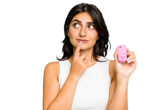 Young Indian Woman Holding A Car Keys Isolated Relaxed Thinking About Something Looking At A Copy Space.